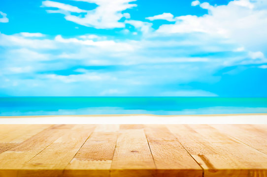 Wood table top on blur white sand beach and blue sky background