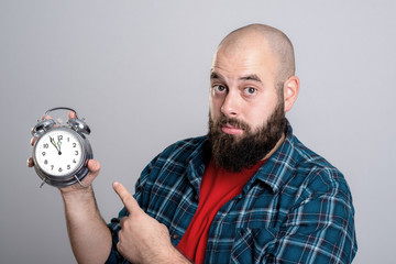 beardet man pointing to a clock