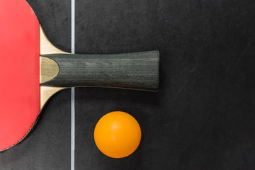 table tennis racket with ball on black table