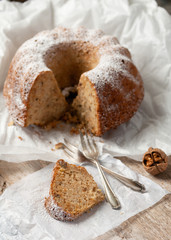Piece of homemade apple, walnut bundt cake with icing sugar. Selective focus.