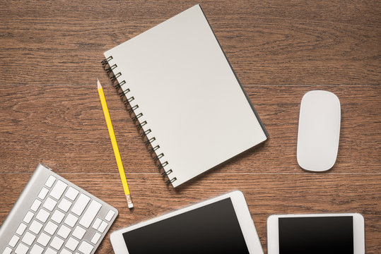 Office wooden table with notebook, yellow pencil, tablet, keyboa