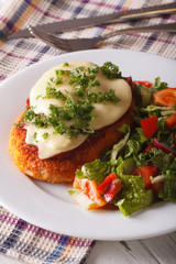 Chicken Parmigiana and fresh vegetable salad close-up. Vertical
