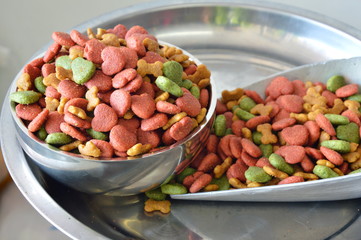 dog food in stainless bowl and iron scoop on weighing scale