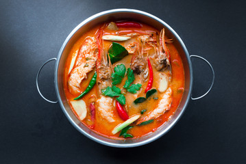 Tom Yum Goong,Thai Food in hot pot, top view on black background