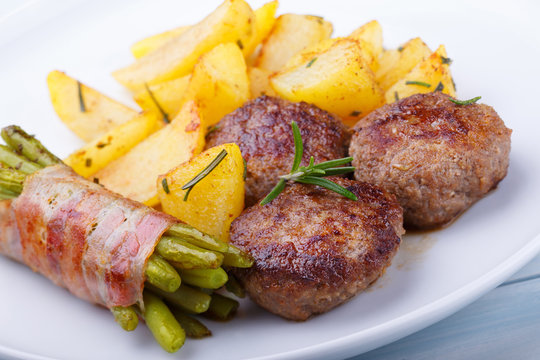 Frikadellen mit Bratkartoffeln und gr&uuml;nen Bohnen im Speckmantel