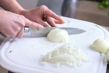 Hände schneiden Zwiebel