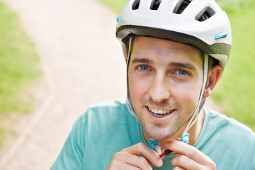 Man Fastening Strap Of Cycling Helmet