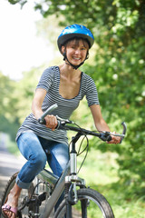 Young Woman Cycling On Country Road