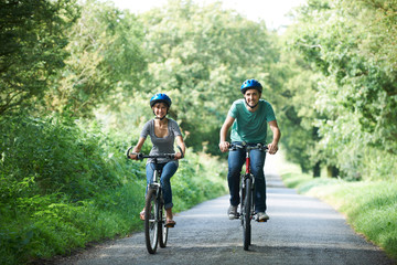 Young Couple Cycling Along Country Lane