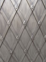 close photo of iron door with pattern of rhombs