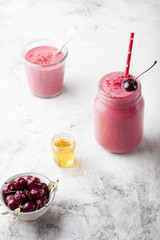 Cherry smoothie, coconut milk, yogurt and honey . Stone background
