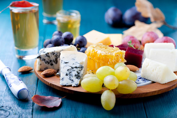 Cheese plate with fresh grape, honey, nuts,plum jelly, marmalade