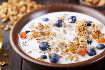 Healthy breakfast. Fresh granola, muesli with berries, honey and milk 