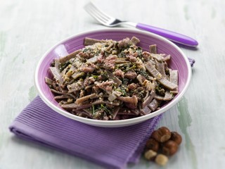 pizzocheri with sausage spinach and hazelnut selective focus