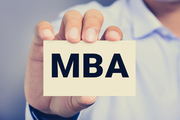 MBA letters (or Master of Business Administration) on the card held by a man hand