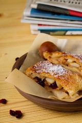 Apple strudel in front of newspapers