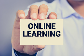 ONLINE LEARNING, messasge on the card shown by a man