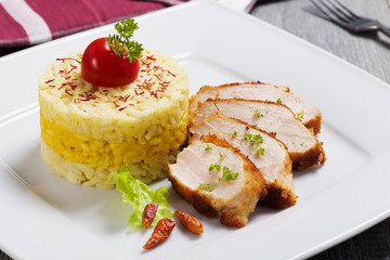 Portion of risotto with roasted chicken.