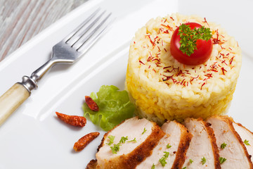 Portion of risotto with roasted chicken.