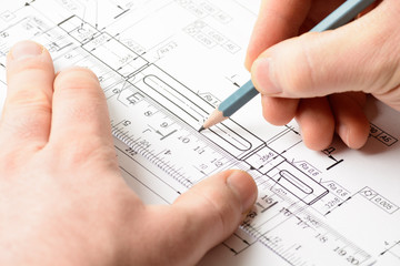 Man's hand holding a pencil on the drawing
