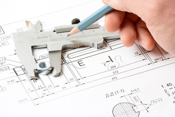 Man's hand holding a pencil on the drawing