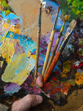 Painter holding a palette for mixing oil paints. The color palette close up.