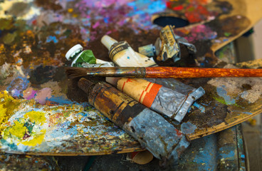 Tubes of paint on a palette for mixing oil paints. Creative mess. The color palette close up.