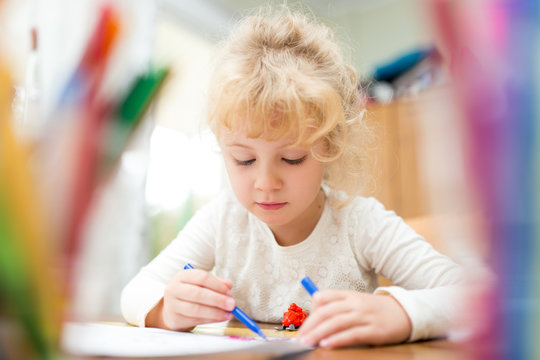 Portrait of child girl drawing at home