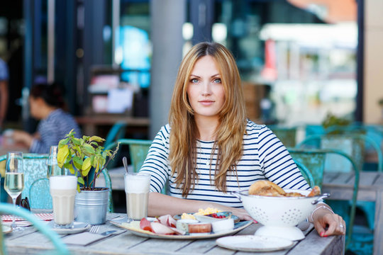 Young woman having healthy breakfast in outdoor cafe