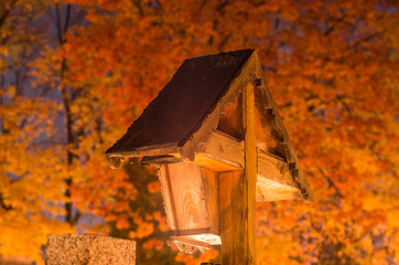 All saints day - cemetery cross with colorful trees illuminated by the grave candles, Krakow, Poland