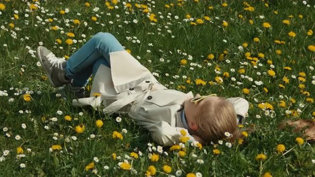 Spring weather. Child lies on the grass and does not do anything. Stretch oneself