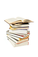 Stack of books and one open book on white background