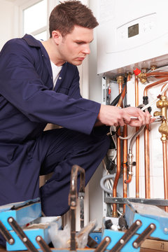 Engineer Servicing Central Heating Boiler