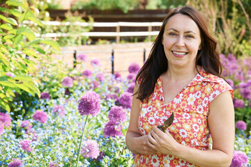 Naklejka premium Middle Aged Woman Gardening At Home