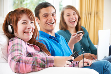 Group Of Friends Using Digital Technology At Home