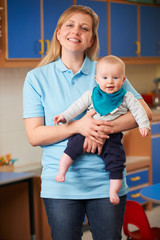 Portrait Of Nursery Worker Holding Baby