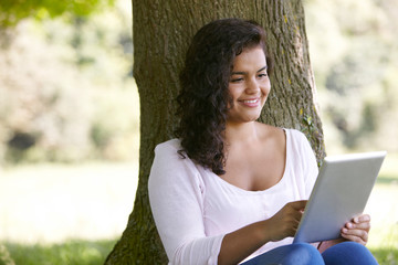 Young Woman Using Digital Tablet In Park