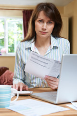 Worried Middle Aged Woman Looking At Home Finances