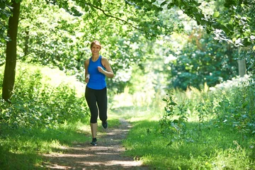 Afwasbaar Fotobehang Joggen Middle Aged Woman Running In Countryside