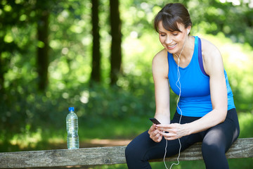 Middle Aged Woman Relaxing With MP3 Player After Exercise
