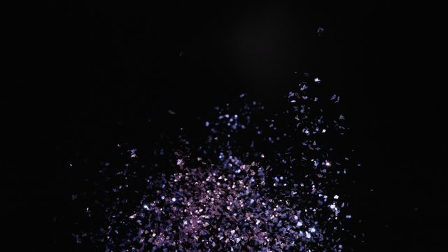 Camera follows colorful confetti flying after being exploded against black background. Shot with high speed camera, phantom flex 4K.  Slow Motion. Unedited version is included at the end of clip.