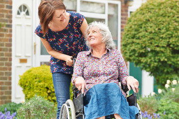 Adult Daughter Pushing Mother In Wheelchair