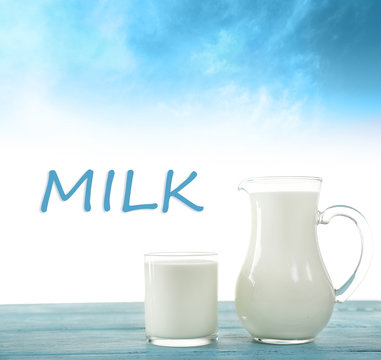 Pitcher and glass of milk on light blue background