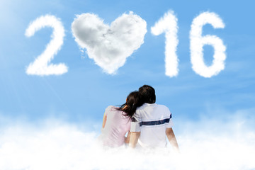 Couple sitting on the cloud with numbers 2016