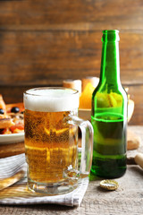 Sliced pizza served with beer on wooden table