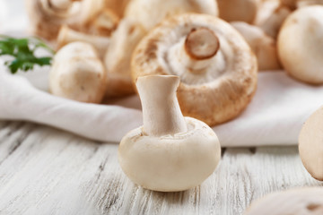 Fototapeta na wymiar Champignon mushrooms on white wooden background
