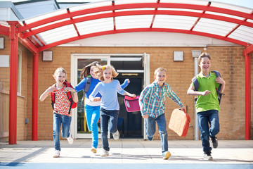 Schoolchildren Running Into Playground At End Of Class