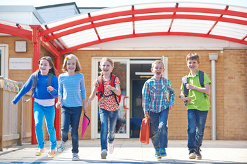 Obraz premium Schoolchildren Running Into Playground At End Of Class