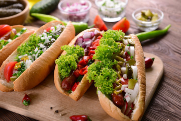 Hot dogs and vegetables on wooden cutting board