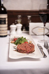 Juicy tartare with vegetables and greens on a plate